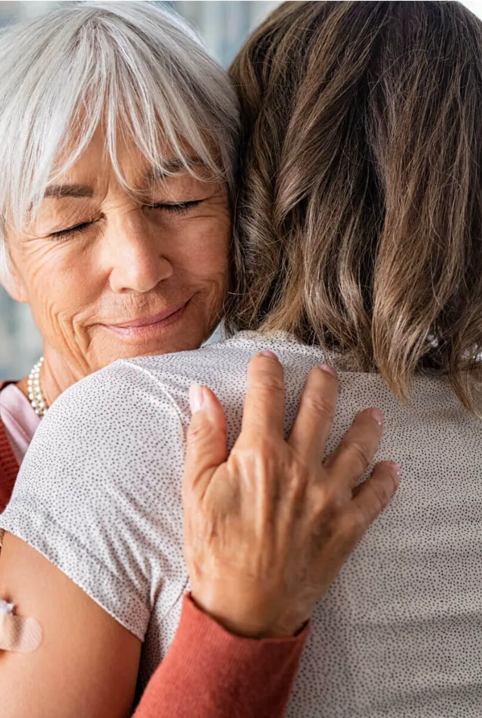 Grateful older woman hugging daughter after ketamine treatment