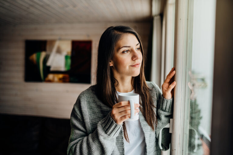 Hopeful woman having coffee thining about Spravato