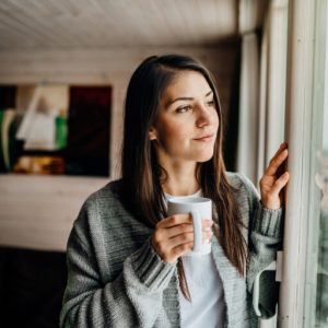 Hopeful woman having coffee thining about Spravato